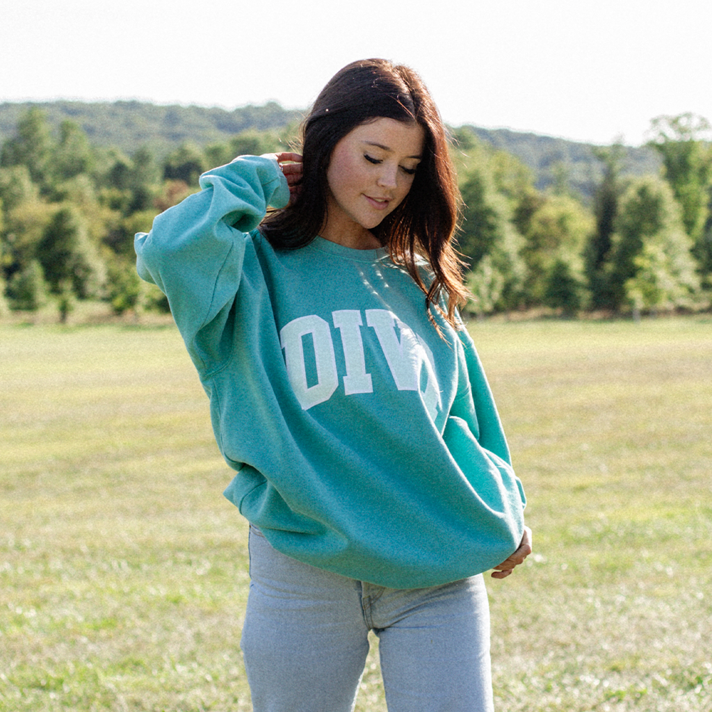 girl wearing divi crewneck in field